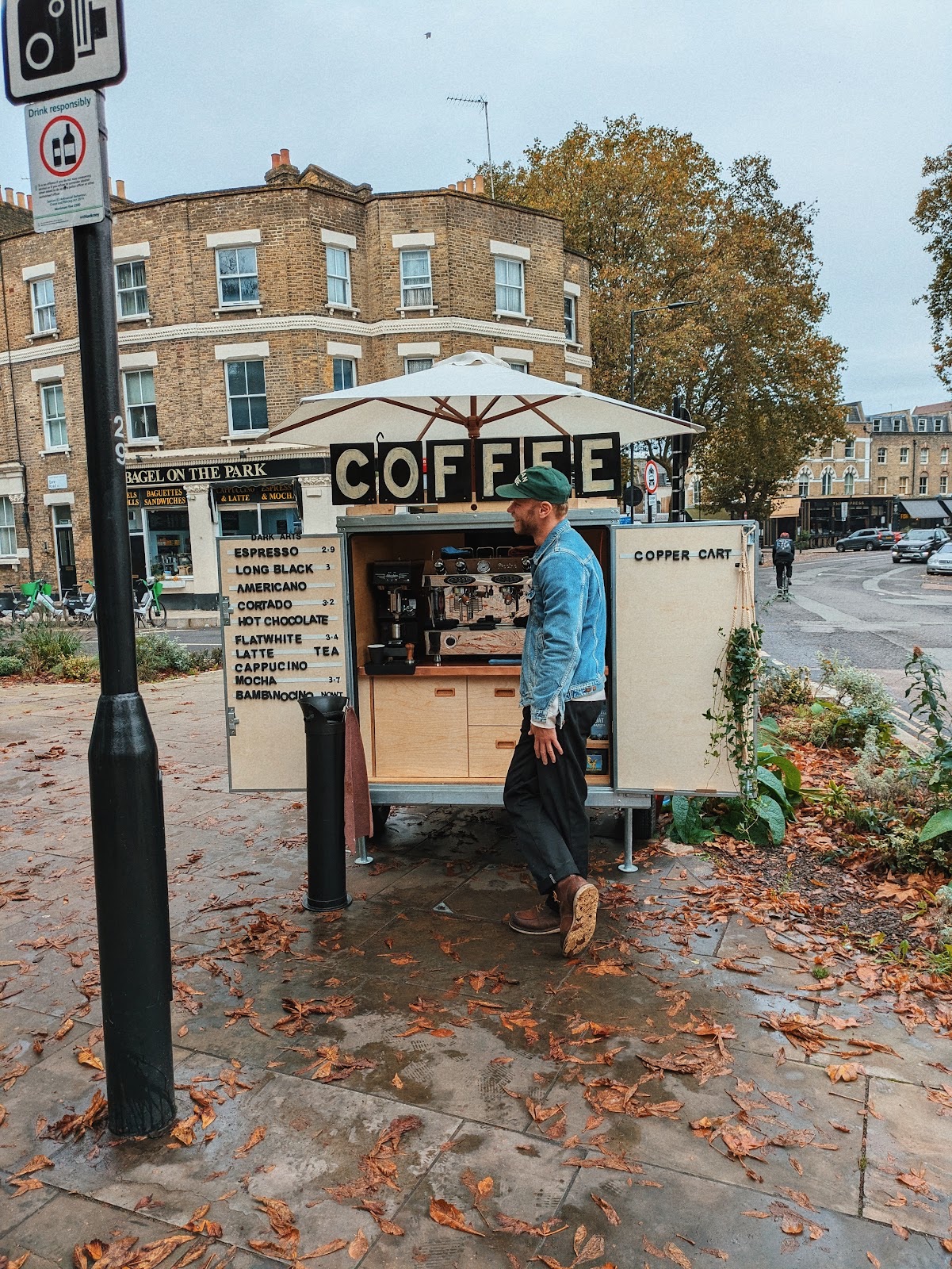 The coffee cart on a leaf-covered corner in autumn with Victorian terraces behind